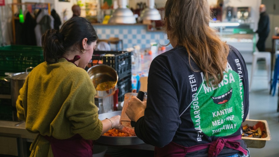 Twee dames in de Mensa Mensa keuken in Rotterdam, locatie de Hillevliet 60, druk bezig met koken.